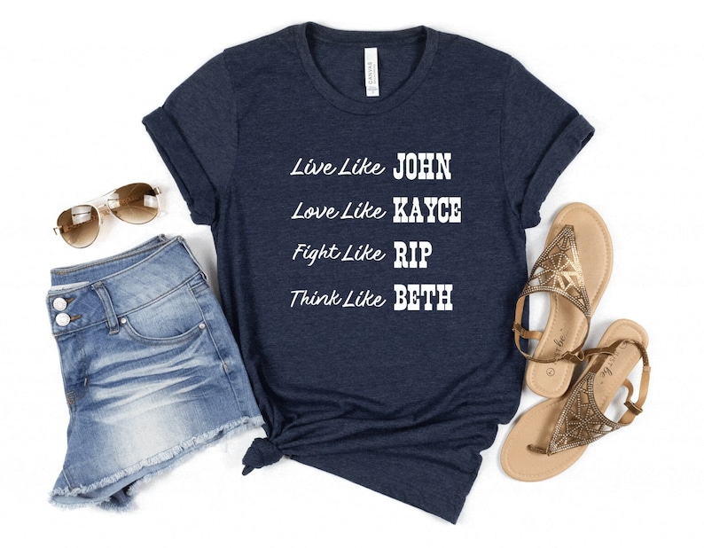 May include: A navy blue t-shirt with white text that reads "Live like JOHN, Love like KAYCE, Fight like RIP, Think like BETH".