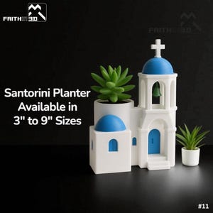May include: A white and blue Santorini planter with a cross on top, a blue door, and a bell. The planter is holding a green succulent. The text on the image says "Santorini Planter Available in 7.6cm to 22.9cm Sizes."