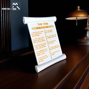 May include: A 3D-printed scroll displaying the Ten Commandments. The text is in black, with the title in a larger font. The scroll is white with a textured surface and has rolled edges. The background is dark with a lamp.
