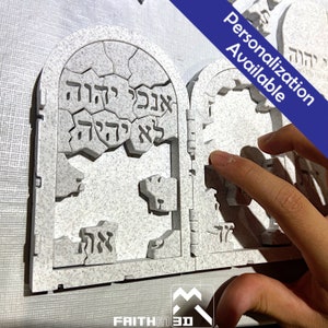 May include: A white, 3D printed, stone-like, two-piece puzzle of the Ten Commandments in Hebrew. The puzzle is broken into pieces and the pieces are arranged in a way that resembles the Ten Commandments. The text on the puzzle reads "אנכי יהוה אלהיך" and "לא יהיה לך אלהים אחרים על פני" which translates to "I am the Lord your God" and "You shall have no other gods before me".