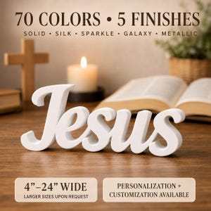 May include: A white, three-dimensional script sign displaying the word Jesus. The text above reads 70 COLOURS 5 FINISHES SOLID SILK SPARKLE GALAXY METALLIC. The text below reads 4-24 WIDE and PERSONALIZATION + CUSTOMIZATION AVAILABLE.