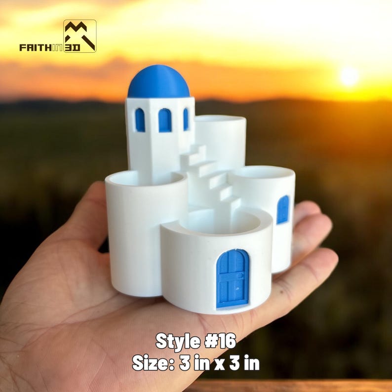 May include: A white and blue miniature architectural model, resembling a Greek island building. The model features a blue dome, arched windows, and a blue door. The text "Style #16" and "Size: 3 in x 3 in" are visible.