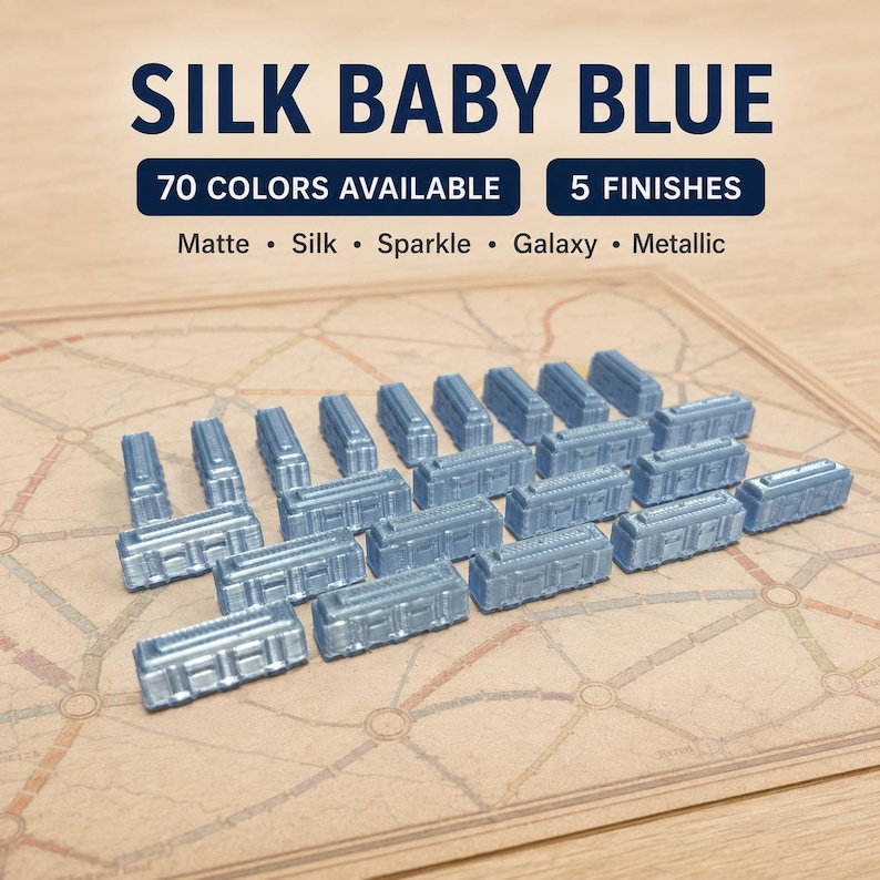May include: A collection of small, light blue, rectangular train game pieces with a silk finish. Text on the image reads: SILK BABY BLUE, 70 COLORS AVAILABLE, 5 FINISHES, Matte, Silk, Sparkle, Galaxy, Metallic. The pieces are arranged on a board.