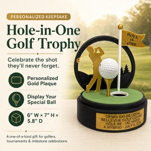 May include: A golf trophy featuring a gold-colored golfer silhouette, a white golf ball on a tee, and a flag with the text HOLE IN ONE. The base includes a gold plaque with the text DENIS SKI BILODEAU BELLEVUE GOLF COURSE HOLE #4 142 YARDS 4 HYBRID JULY 8, 2026.