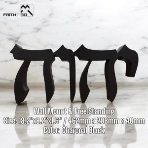 May include: Black wooden wall art featuring the Hebrew word "יהוה" (YHWH) in a traditional script. The art piece is 18.2 inches wide, 8.2 inches tall, and 1.6 inches deep. It can be mounted on a wall or displayed freestanding.