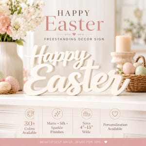 May include: A white freestanding decor sign with the words Happy Easter in a cursive script font. The sign is displayed on a surface with text indicating 30+ colours available, matte, silk, and sparkle finishes, and sizes from 10 to 38 cm wide.