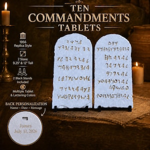 May include: Two light-colored, arched stone tablets featuring engraved ancient script in gold. The tablets are displayed on small black stands. Text on the image indicates 1956 replica style, 9.25-inch and 12-inch heights, and back personalization options including name, date, and message.