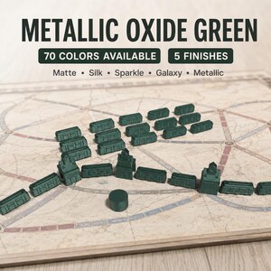 May include: A collection of dark green plastic train cars and station pieces arranged on a board game map. Text at the top reads METALLIC OXIDE GREEN, 70 COLORS AVAILABLE, 5 FINISHES, Matte, Silk, Sparkle, Galaxy, Metallic.