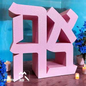 Peut inclure: Une grande sculpture de lettre en mousse rose clair en trois dimensions, présentant un design de police angulaire stylisé. La structure possède une surface texturée et des sections creuses ouvertes dans les formes des lettres.