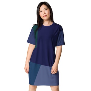 May include: A navy blue, green, and blue geometric print t-shirt dress. The dress has a relaxed fit and short sleeves.