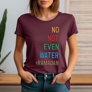 Op de afbeelding: Een maroon t-shirt met de tekst "NO NOT EVEN WATER #RAMADAN" in kleurrijke letters.