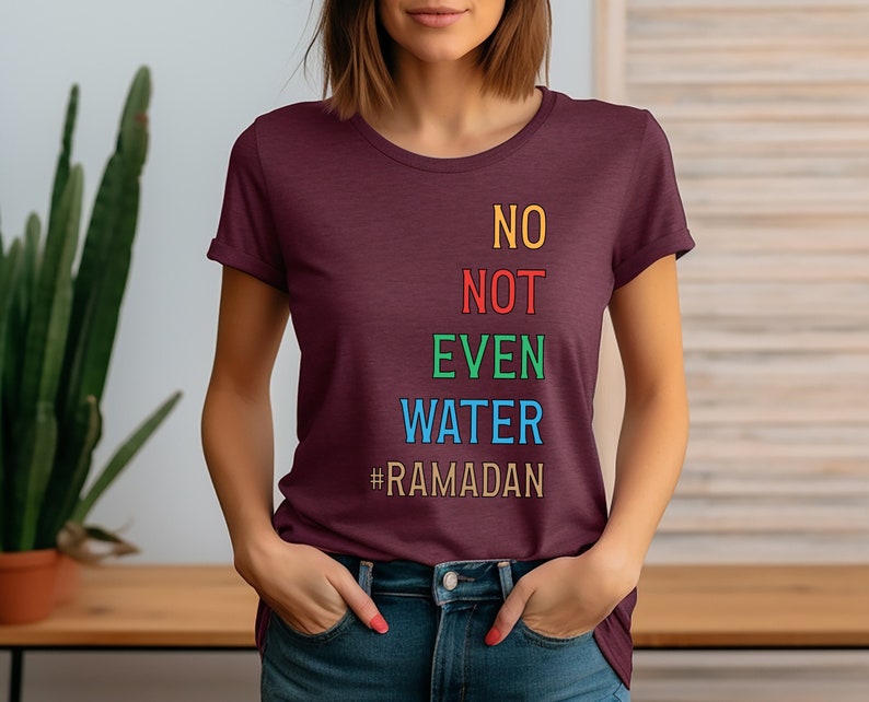 Op de afbeelding: Een maroon t-shirt met de tekst "NO NOT EVEN WATER #RAMADAN" in kleurrijke letters.