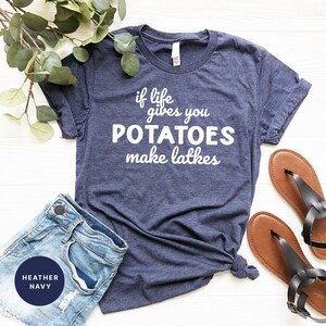 Peut inclure: Un t-shirt bleu marine chin&eacute; avec le texte "if life gives you POTATOES make latkes" imprim&eacute; en blanc.