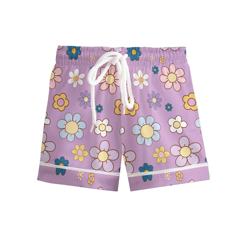 Puede incluir: Pantalones cortos de color lavanda con cord&oacute;n blanco y ribete blanco. Los pantalones cortos tienen un estampado de flores coloridas en tonos azules, amarillos y rosas. Los pantalones cortos son de material suave.
