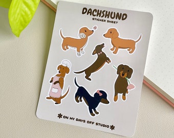 May include: A sticker sheet featuring six different dachshund illustrations. The dachshunds are depicted in various poses, including wearing a chef's hat and apron, holding a flower, and wearing a bow. The sticker sheet is labeled "Dachshund Sticker Sheet" and "*On My Days Off Studio*".