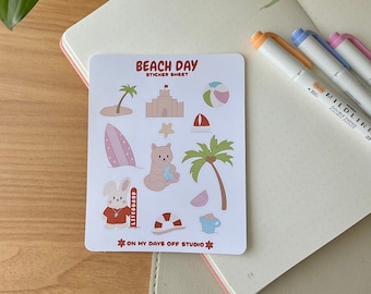 May include: A sticker sheet with a beach theme. It features a variety of stickers, including a palm tree, a sandcastle, a beach ball, a surfboard, a bear, a bunny, a lifeguard, a life preserver, a watermelon, and a bucket and shovel. The sticker sheet is white with red, blue, and yellow accents. The text "Beach Day Sticker Sheet" is printed in red at the top of the sheet. The text "On My Days Off Studio" is printed in red at the bottom of the sheet.