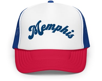 Può includere: Un cappello da camionista bianco e rosso con una rete blu sul retro. La parte anteriore del cappello ha la parola "Memphis" ricamata in blu.