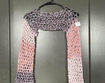May include: A crocheted top with long sleeves in shades of pink and purple. The top is made of a loose, open weave and has a relaxed fit.