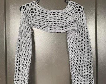 May include: A gray crochet shrug with a wide, open neckline and long sleeves. The shrug is made of a lightweight, open-weave fabric.