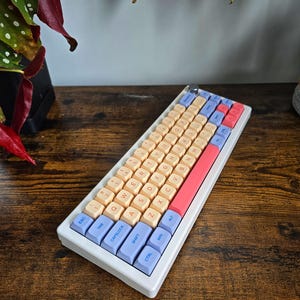 May include: A set of three ceramic mugs with a speckled, matte finish. The mugs are in shades of cream, gray, and black. Each mug has a simple, modern design, perfect for coffee or tea.