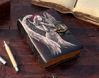 May include: A black leather journal with a detailed illustration of an angel with wings on the cover. The journal has a metal clasp and a red and black design.