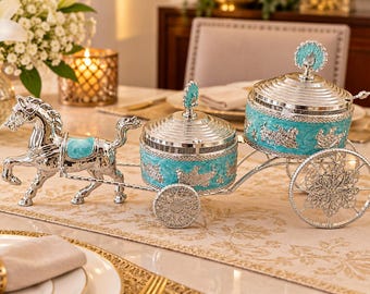 May include: A silver-toned horse-drawn carriage serving set featuring two round containers with lids. The horse and carriage frame are polished silver with bright turquoise enamel accents and intricate floral-style embossed metal detailing.