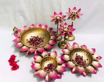 May include: Set of four gold and pink lotus flower shaped bowls with a hammered metal finish. Each bowl has a small, round depression in the center and is filled with dried rose petals.