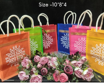 May include: Set of four colorful jute gift bags with white rope handles. Each bag features a white geometric design and a gold trim. The bags are arranged in a row with pink flowers in front. Size - 10*8*4