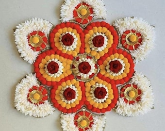 May include: A floral arrangement in a starburst pattern. The design features a central cluster of red, yellow, and white flowers, surrounded by larger white and red petal-shaped elements. Gold accents are visible throughout the design.
