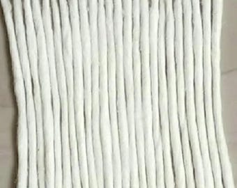 May include: A collection of twenty-two individual white cotton wicks arranged in a parallel vertical row. Each wick features a slender, cylindrical, and fibrous texture with a slightly tapered end, presenting a uniform appearance across the set.