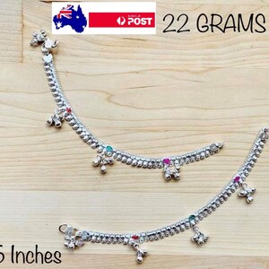 May include: Two silver anklets with small bells and colourful stones. The anklets are 6.5 inches long and weigh 22 grams.