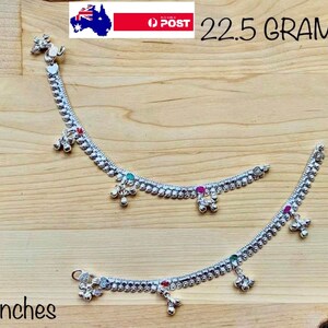 May include: Two silver anklets with small bells and colourful stones. The anklets are 7 inches long and weigh 22.5 grams.