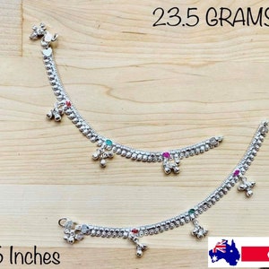 May include: Two silver anklets with small bells and colourful stones. The anklets are 7.5 inches long and weigh 23.5 grams.