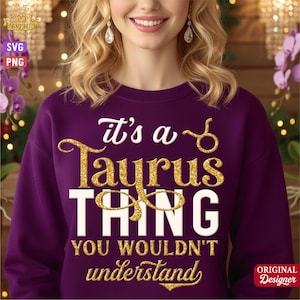 Puede incluir: Una sudadera morada con la frase "It's a Taurus Thing You Wouldn't Understand" en letras blancas y doradas brillantes. El diseño incluye el símbolo del signo zodiacal Tauro. La sudadera es de cuello redondo.