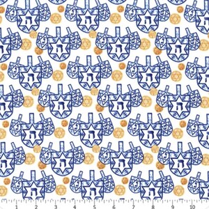 Peut inclure: Tissu blanc avec un motif répété de toupies bleues et d'étoiles de David dorées. Les toupies ont un motif d'étoile et des lettres hébraïques. Parfait pour les créations et projets sur le thème de Hanoucca.