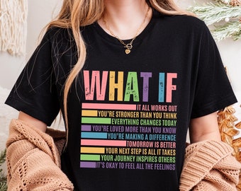 May include: Black t-shirt with the text "WHAT IF" in rainbow colours. The text is followed by a list of positive affirmations in a rainbow colour scheme. The affirmations include: "It all works out", "You're stronger than you think", "Everything changes today", "You're loved more than you know", "You're making a difference", "Tomorrow is better", "Your next step is all it takes", "Your journey inspires others", and "It's okay to feel all the feelings".