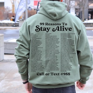 May include: A green hooded sweatshirt with the text "99 Reasons To Stay Alive" and a phone number printed on the back.