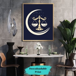 May include: A printable wall art design featuring a gold Libra zodiac symbol on a blue background with a crescent moon and stars. The design is framed and displayed in a modern interior setting.