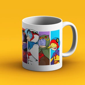 Op de afbeelding: Witte keramische mok met een kleurrijke illustratie van vijf cartoonfiguren. De personages dragen verschillende gekleurde kostuums en hebben unieke gezichtsuitdrukkingen. De mok heeft een zwart handvat.