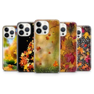 May include: Set of five iPhone cases featuring autumn leaf designs. The cases have a clear background and showcase different arrangements of colorful leaves, including red, orange, yellow, and brown.