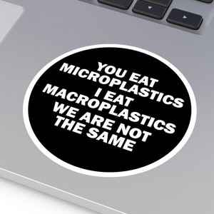May include: A black and white sticker with the text "You eat microplastics I eat macroplastics We are not the same."