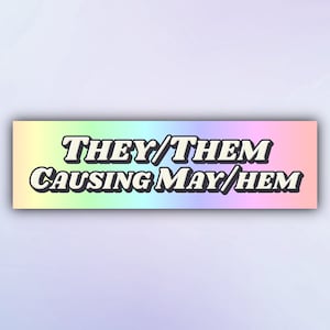 May include: A rainbow gradient background with the text "THEY/THEM CAUSING MAY/HEM" in white with a black outline.