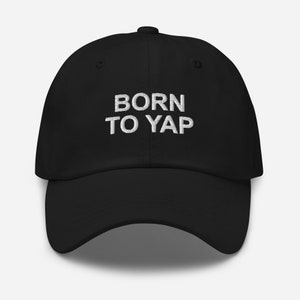 Peut inclure: Une casquette de baseball noire avec un texte brodé blanc qui dit "BORN TO YAP".