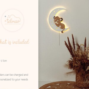 May include: A white crescent moon-shaped wall light with a sleeping lion cub design. The light has a warm glow and is connected to a power source. The image also includes a decorative floral arrangement in a woven basket.