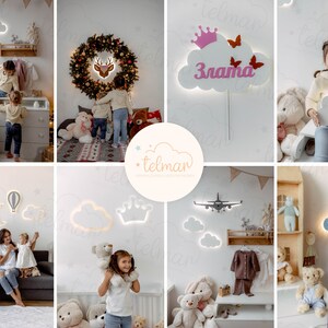 May include: A collection of wooden cloud night lights with different designs, including a hot air balloon, a plane, a crown, and a crescent moon. Some of the clouds have names written on them, such as "Zlata" and "Moonlight".