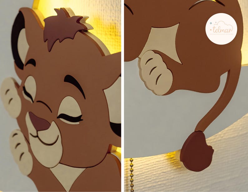 May include: A brown and beige lion cub-shaped wall lamp. The lamp features a smiling lion cub with closed eyes and a tail. The lamp is made of wood and has a warm, yellow light. The lamp is designed for a nursery or children's room.