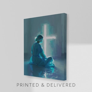 May include: A canvas print featuring a person in medical scrubs kneeling in front of a glowing cross. The artwork is rendered in shades of blue and white, with the text "PRINTED & DELIVERED" at the bottom.