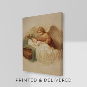 May include: A canvas print of a vintage illustration featuring an angel with large wings, gently watching over a sleeping child. The artwork is in soft, muted tones with the text "PRINTED & DELIVERED" at the bottom.