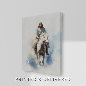 May include: A canvas print depicts a person riding a white horse. The rider wears light-colored robes. The background features soft blue and white watercolor-style washes. The text "PRINTED & DELIVERED" is printed at the bottom.