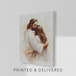 May include: A canvas print depicts a tender embrace between two figures. One figure, with long brown hair and a beard, wears a white robe, embracing another figure with long brown hair. The text "PRINTED & DELIVERED" is at the bottom.